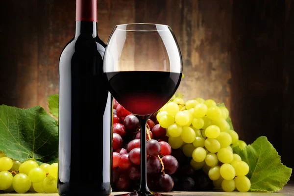 Composition with glass, bottle of red wine and fresh grapes — Stock Photo, Image