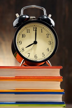 Eski siyah çalar saat kitap yığını üzerinde