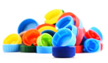 Plastik şişe kapakları beyaz arka planda izole edilmiş.