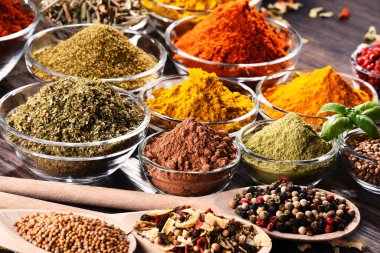 Mutfak masasında çeşitli baharat ve bitkiler var..