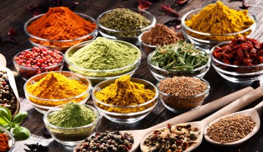 Mutfak masasında çeşitli baharat ve bitkiler var..