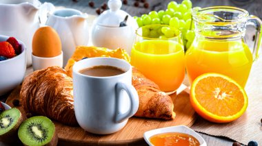 Kahve, portakal suyu, kruvasan, tahıl ve meyve ile kahvaltı. Dengeli beslenme.