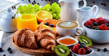 Kahve, portakal suyu, kruvasan, tahıl ve meyve ile kahvaltı. Dengeli beslenme.
