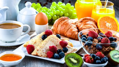 Kahve, portakal suyu, kruvasan, tahıl ve meyve ile kahvaltı. Dengeli beslenme.