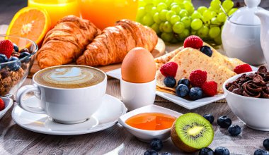 Kahve, portakal suyu, kruvasan, tahıl ve meyve ile kahvaltı. Dengeli beslenme.