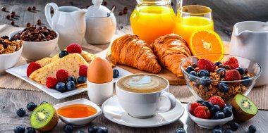 Kahve, portakal suyu, kruvasan, tahıl ve meyve ile kahvaltı. Dengeli beslenme.