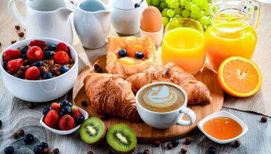 Kahve, portakal suyu, kruvasan, tahıl ve meyve ile kahvaltı. Dengeli beslenme.