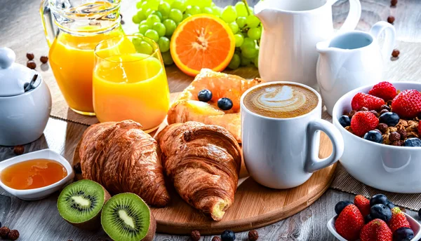 Kahve, portakal suyu, kruvasan, tahıl ve meyve ile kahvaltı. Dengeli beslenme.