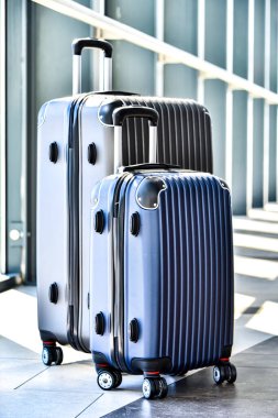 İki plastik seyahat bavul Havaalanı koridorda.