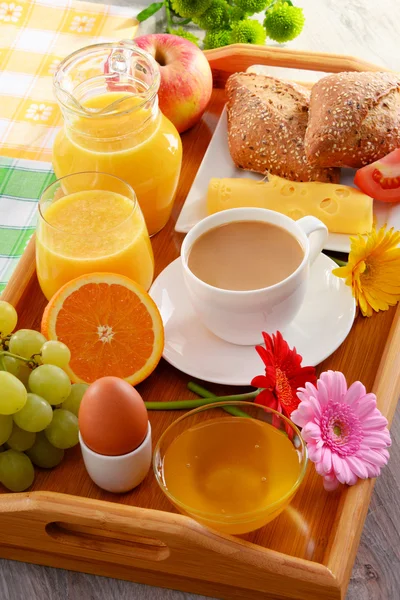 Desayuno en bandeja servido con café, jugo, huevo y panecillos — Foto de Stock