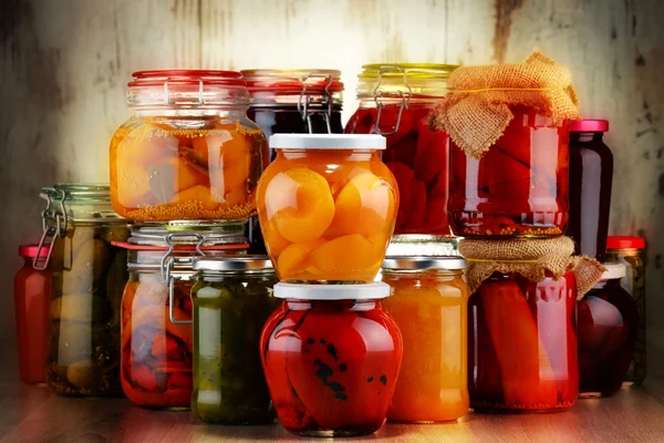 Баночки з маринованими овочами та фруктовими компотами — стокове фото