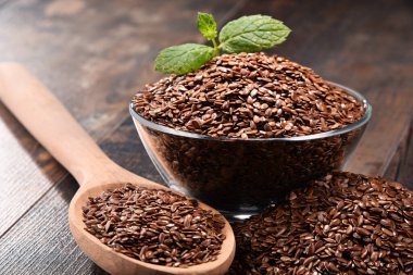 Ahşap masa üzerinde keten tohumu kase ile kompozisyon.