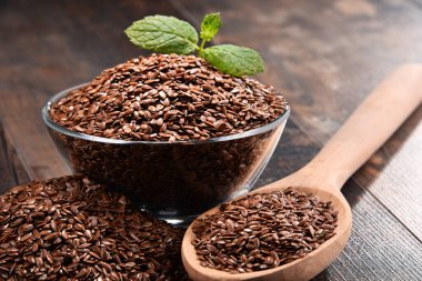 Ahşap masa üzerinde keten tohumu kase ile kompozisyon.