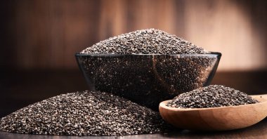 Chia tohum ahşap masa üzerinde kase ile kompozisyon.