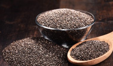 Chia tohum ahşap masa üzerinde kase ile kompozisyon.