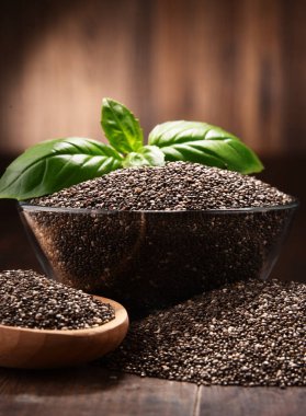 Chia tohum ahşap masa üzerinde kase ile kompozisyon.