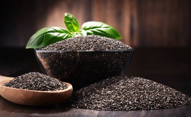 Chia tohum ahşap masa üzerinde kase ile kompozisyon.