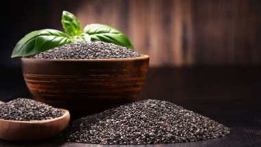 Chia tohum ahşap masa üzerinde kase ile kompozisyon.