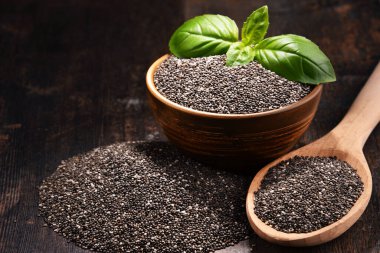 Chia tohum ahşap masa üzerinde kase ile kompozisyon.