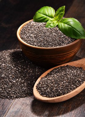 Chia tohum ahşap masa üzerinde kase ile kompozisyon.