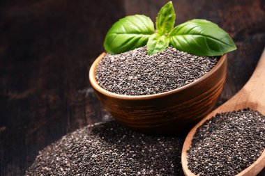 Chia tohum ahşap masa üzerinde kase ile kompozisyon.