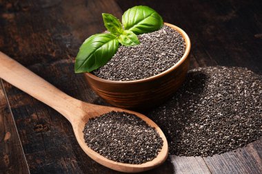 Chia tohum ahşap masa üzerinde kase ile kompozisyon.