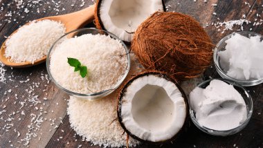 Ahşap masa üzerinde parçalanmış hindistan cevizi ve kabuklu kompozisyon