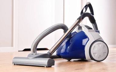 Dairedeki zemin panellerinde ev kullanımı için teneke süpürge..