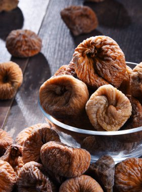 Ahşap masada bir kase kurutulmuş incir ile kompozisyon.