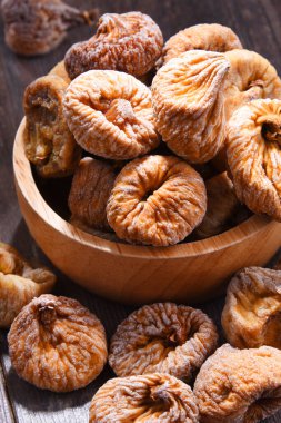 Ahşap masada bir kase kurutulmuş incir ile kompozisyon.