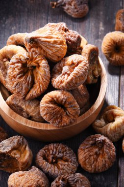 Ahşap masada bir kase kurutulmuş incir ile kompozisyon.