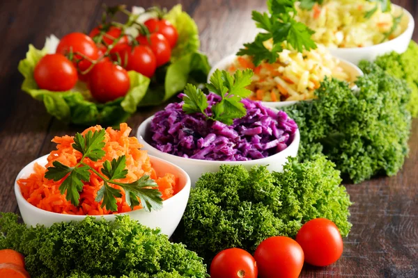 Composition with four vegetable salad bowls on wooden table — Stock Photo, Image