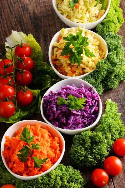 Composition with four vegetable salad bowls on wooden table — Stock Photo, Image