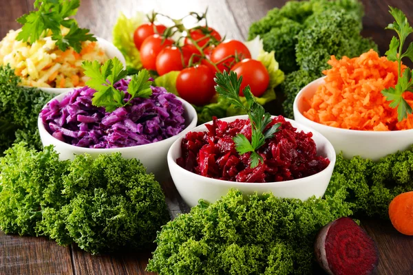 Composición con cuatro ensaladeras de verduras sobre mesa de madera —  Fotos de Stock