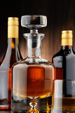 Çeşitli alkollü içecekler ve bardak viski şişeleri