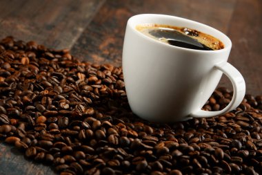 Beyaz fincan kahve çekirdekleri ile kompozisyon