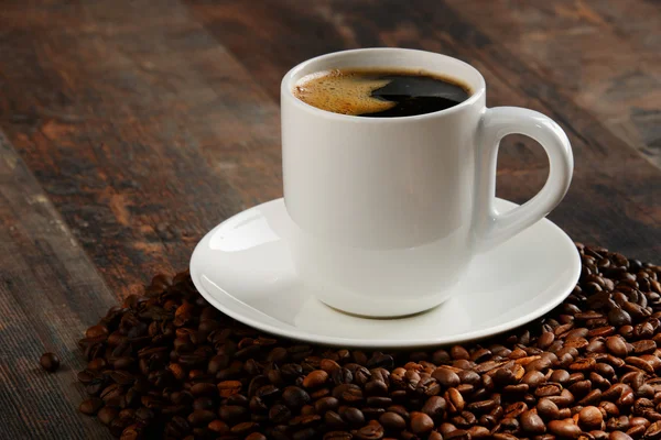 Состав с белой чашкой и кофейными зёрнами — стоковое фото