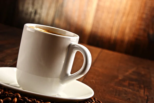 Состав с белой чашкой и кофейными зёрнами — стоковое фото