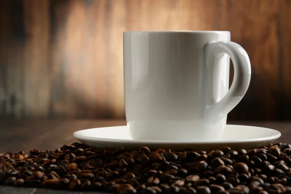 Composição com xícara branca e grãos de café — Fotografia de Stock