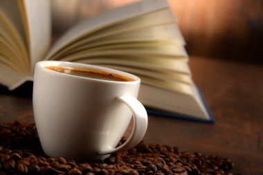 Beyaz fincan kahve ve açık kitap ile kompozisyon