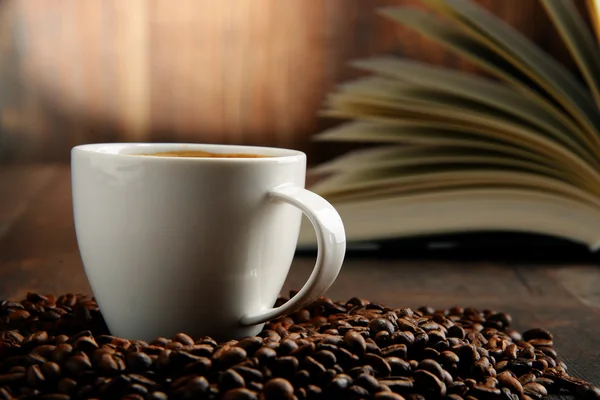 Sammansättning med vit kopp kaffe och öppen bok Royaltyfria Stockbilder