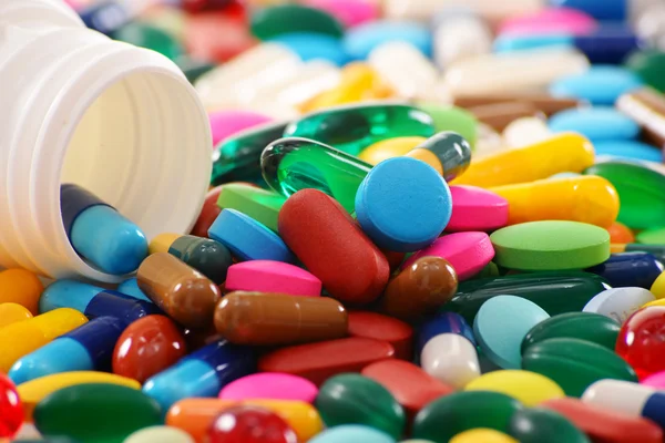 Composição com variedade de pílulas de drogas e recipiente — Fotografia de Stock
