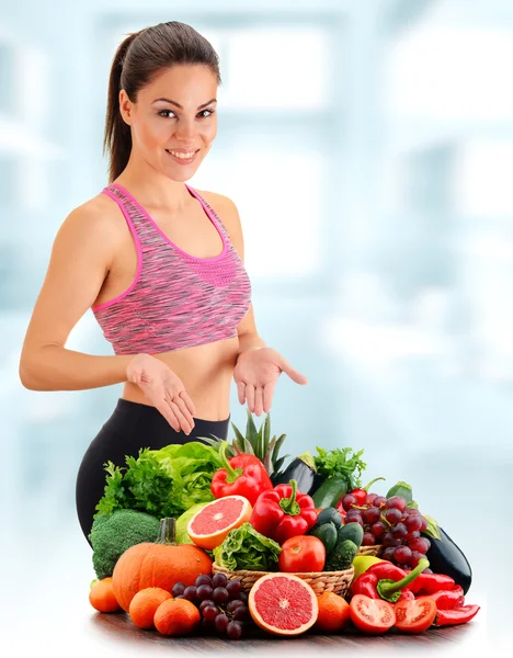 Mujer joven con variedad de verduras y frutas orgánicas — Foto de Stock