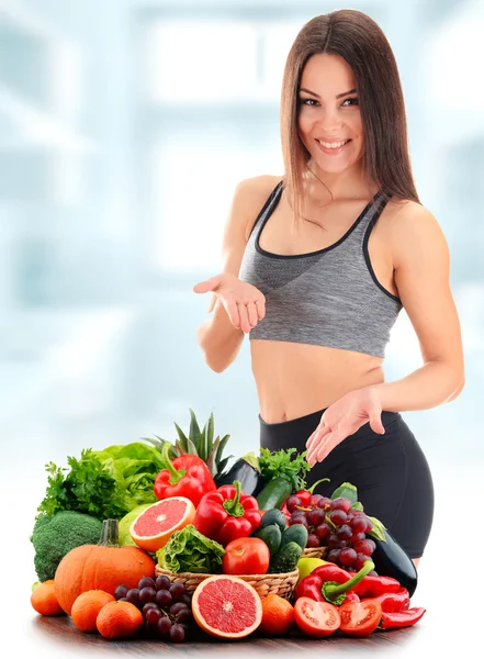 Mujer joven con variedad de verduras y frutas orgánicas — Foto de Stock