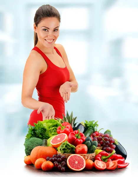 Mujer joven con variedad de verduras y frutas orgánicas — Foto de Stock