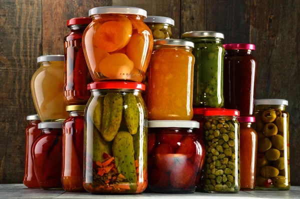 Gläser mit eingelegtem Gemüse, fruchtigen Kompotten und Marmeladen — Stockfoto