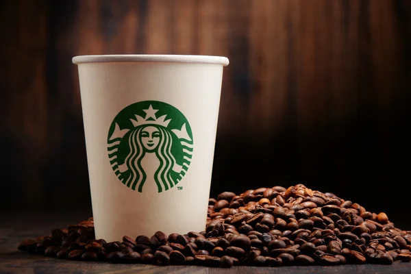 Composition with cup of Starbucks coffee and beans — Stock Photo, Image