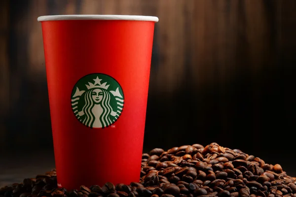 Složení s šálkem kávy Starbucks a fazole — Stock fotografie