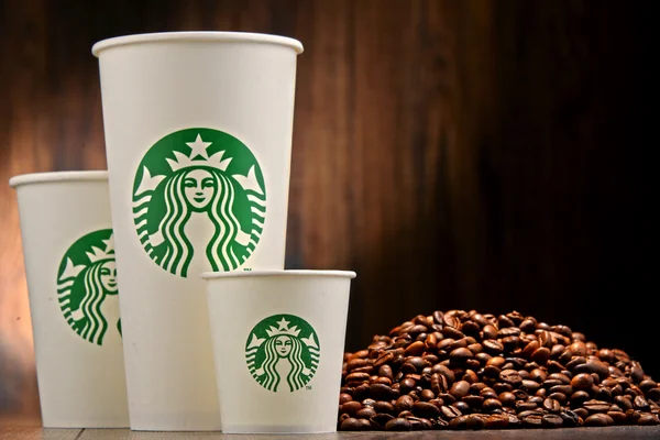 Sammansättning med kopp kaffe från Starbucks och bönor — Stockfoto