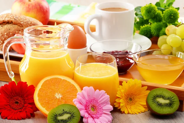 Petit déjeuner sur plateau servi avec café, jus de fruits, œufs et petits pains — Photo